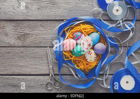 Colorful Easter Eggs in a Basket With Crafting Supplies on a Wooden Table Stock Photo