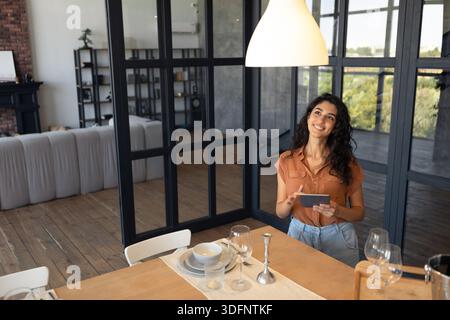 Modern technologies in daily life. Portraif of happy young woman using digital tablet at kitchen, copy space Stock Photo