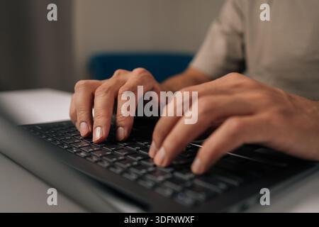 Close-up hands of unrecognizable programmer male typing code on laptop keyboard, showcasing process of software development and coding expertise. Stock Photo