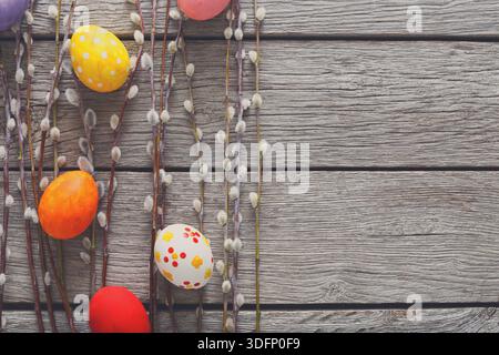 Colorful Eggs and Willow Branches Arranged on Rustic Wooden Surface for Spring Celebration Stock Photo