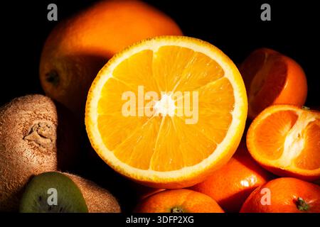 sliced orange tropical fruit mix on black background Stock Photo