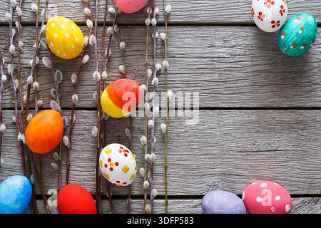 Colorful Easter Eggs Arranged With Willow Branches on Rustic Wooden Background Stock Photo
