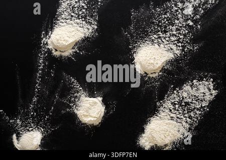 Sprinkled wheat flour splash spots on black background Stock Photo