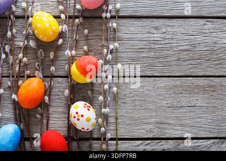 Colorful Easter Eggs Arranged on Wooden Surface With Willow Branches Decor Stock Photo