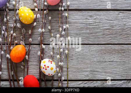 Colorful Easter Eggs Arranged With Willow Branches on Rustic Wooden Surface Stock Photo