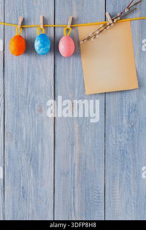 Colorful Easter Eggs Hanging on a String With a Blank Note in Springtime Setting Stock Photo