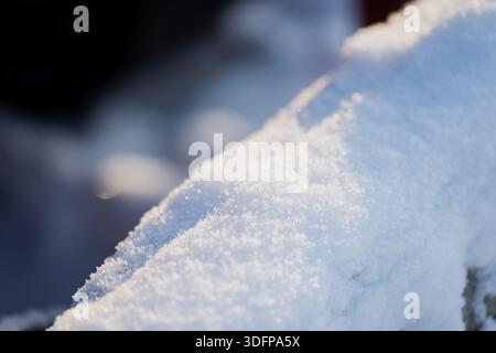 Macro close up of fresh snow surface with sparkling ice crystals in winter sunlight, soft bokeh background and cool blue tones creating abstract textu Stock Photo