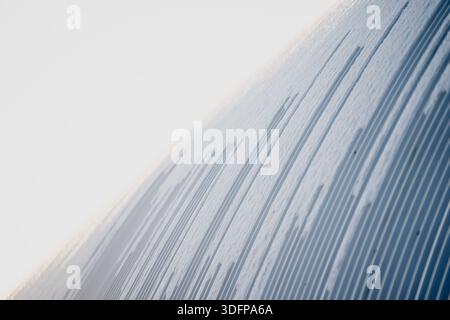 Abstract winter background of shallow ridges and lines in snow, close view of textured surface with smooth gradients and minimal composition in daylig Stock Photo