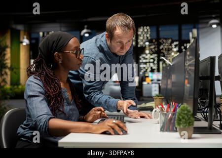 Software developers cooperating in AI focused startup, designing, coding and debugging applications. System administrators doing brainstorming, testing machine learning code, doing quality assurance Stock Photo