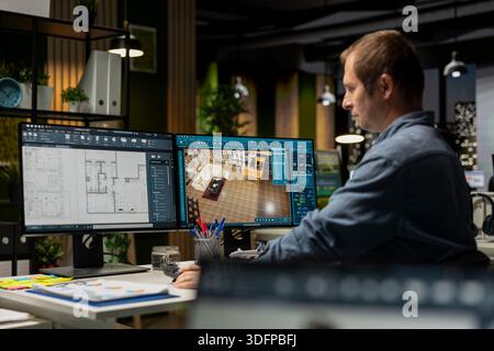 Expert designer decorating apartment floor plan using blueprints on pc, using architectural software to configure elements. Focused man uses interface to enable rendering and 3D modeling. Stock Photo