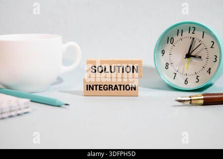 Concept of solution integration write on sticky notes isolated on Wooden Table. Stock Photo