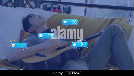 Reclining teenage male napping on couch at window holding guitar headset and reactions, copy space Stock Photo