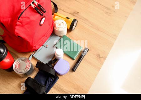 Emergency backpack with necessities on desk in classroom, top view Stock Photo