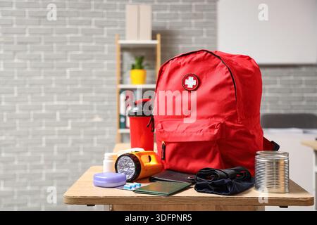 Emergency backpack with necessities on desk in classroom Stock Photo