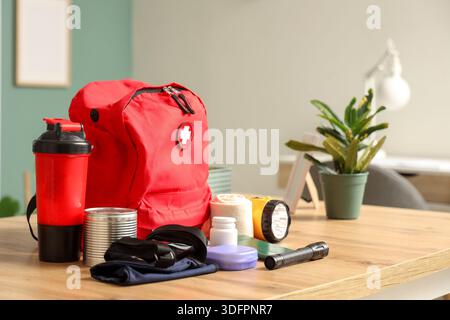 Emergency backpack with necessities on desk in classroom Stock Photo