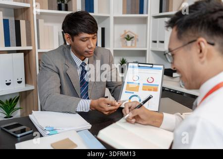 Business professionals discussing sales performance and management strategies during a company meeting, focusing on analysis, decision making, and col Stock Photo
