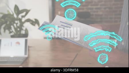Holding printed report, hands in blue shirt reading charts at wooden desk with laptop AR icons Stock Photo