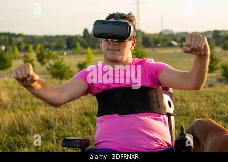 Inclusive technology concept showing a man in a wheelchair immersed in virtual reality in a sunny meadow. Stock Photo