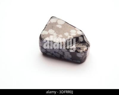 Close up of a black snowflake obsidian healing stone on a white background, Concept of healing stone helps you relax and protects you from negativity Stock Photo
