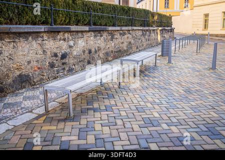 Modern city benches in old city with stone pavement Stock Photo