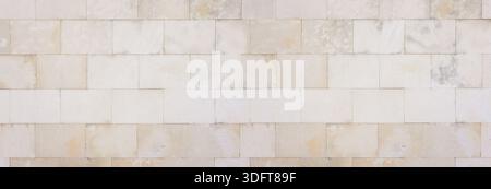 Pale beige rectangular stone blocks forming a textured architectural wall Stock Photo