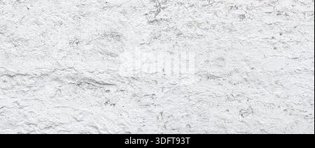 White painted brick wall showing rough, weathered texture and grunge background Stock Photo