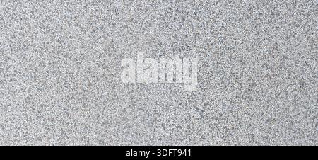 Gray concrete surface showing many small granite and stone aggregate pebbles Stock Photo