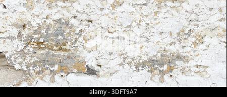 Grungy distressed concrete wall texture revealing cracks and underlying construction Stock Photo