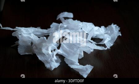White torn and crumpled tissue, handkerchief scraps isolated on black background, side view. Stress relief. High quality photo Stock Photo