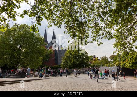 COLOGNE, GERMANY - MAY 31, 2024: People and children playing with soap bubbles in a public square in Cologne, Germany, with the iconic Cologne Cathedr Stock Photo