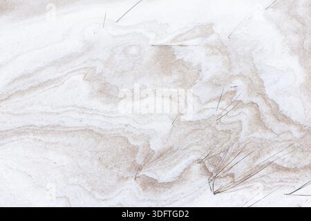 Snow mixed with sand, top view, frozen dune wavy pattern. Baltic Sea coast on a sunny winter day. Beach ground texture with shadows. Abstract natural Stock Photo