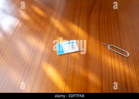 Sim Card and Eject Pin. sim card on desk, close-up Stock Photo