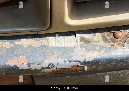 Closeup detail of rusty car bumper showing severe corrosion and peeling paint texture neglected old vehicle grill surface with worn metal automotive b Stock Photo