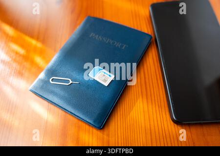 Sim Card and passport next to smartphone. sim card on passport, close-up Stock Photo