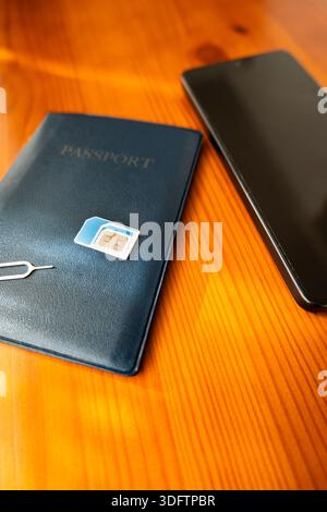 Sim Card and passport next to smartphone. sim card on passport, close-up Stock Photo