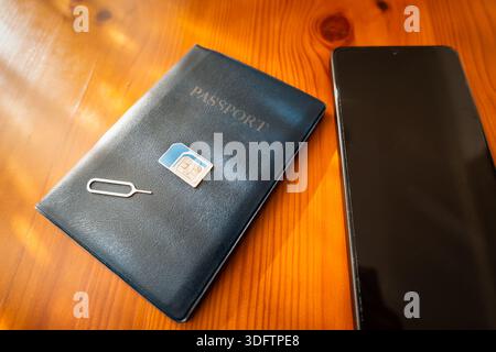 Sim Card and passport next to smartphone. sim card on passport, close-up Stock Photo