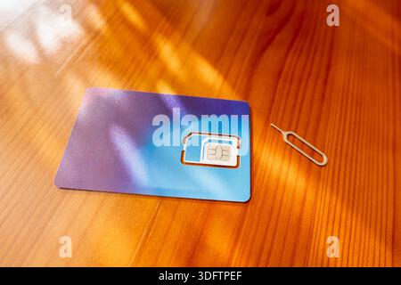 Sim Card and Eject Pin. sim card on desk, close-up Stock Photo