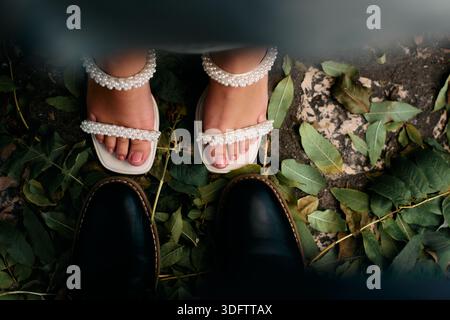 Top Down View of a Couples Feet Standing on Fallen Leaves. Romantic Meeting Concept Stock Photo