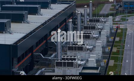 Aerial view of a modern data center's cooling infrastructure juxtaposes dark metal against the pale sky, Agriport, Middenmeer, Netherlands. Stock Photo