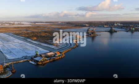 Aerial view of windmills standing tall against the horizon, casting long shadows on the water, Zaanse Schans, North Holland, Netherlands. Stock Photo