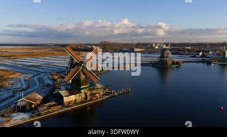 Aerial view of windmills standing majestically against the tranquil waters, their silhouettes mirrored in the serene expanse, Zaanse Schans, Netherlan Stock Photo