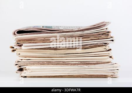 a large stack of newspapers on the table Stock Photo