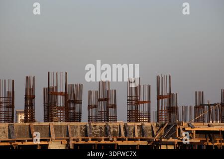 Close-up view of a modern steel girder building structure under construction against a clear blue sky, showing architectural details and framework Stock Photo