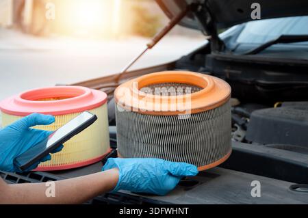 The mechanic is inspecting the old engine air filter. Stock Photo