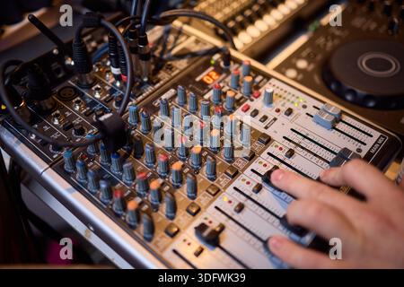 Engineer finetuning sound signals using patch cables, Focused technician adjusting levels on electronic patch cable setup with vivid colorful plugs Stock Photo