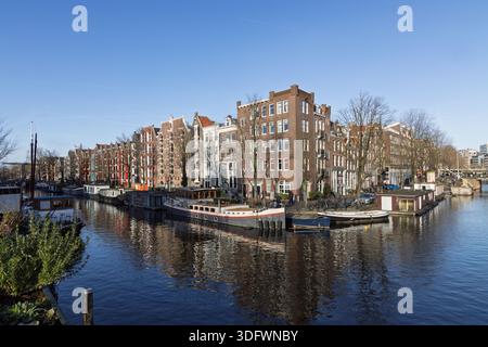 Amsterdam, Netherlands: Scenic view of the intersection of Brouwersgracht and Korte Prinsengracht canals, featuring houseboats and historic brick hous Stock Photo