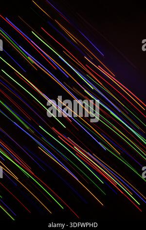 A vibrant and abstract image showcasing a chaotic yet beautiful arrangement of colorful light trails against a dark background. The dynamic lines crea Stock Photo