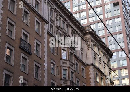 Historic brick residential buildings with bay windows along a street, modern high-rise towers rising in background, downtown Toronto, Ontario, Canada. Stock Photo