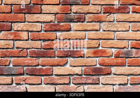 Old weathered red brick wall as background. Bricks masonry with seams. Red brick wall texture Stock Photo