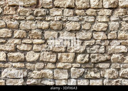 Weathered grey stone wall as creative background texture Stock Photo